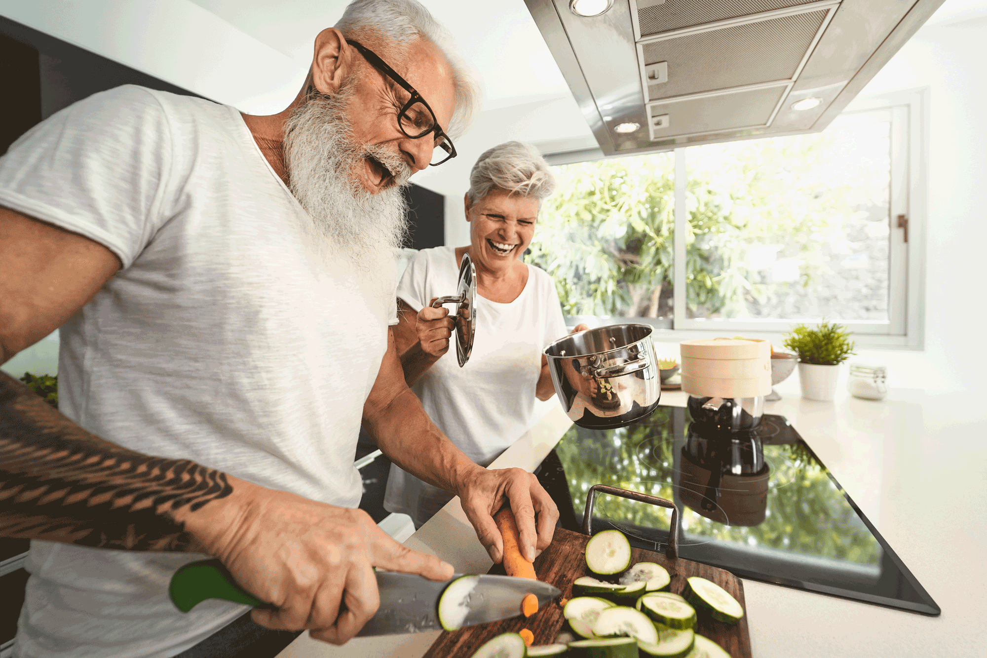 Älteres Paar kocht und lacht zusammen in der Küche
